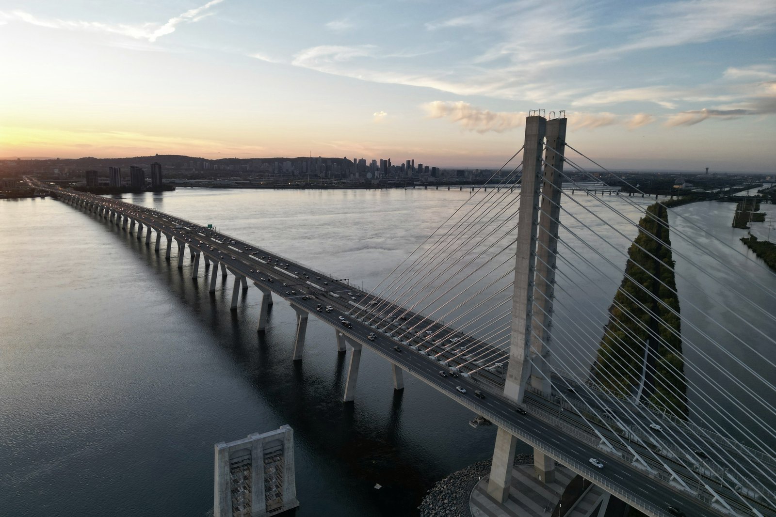 The Samuel De Champlain Bridge at dusk, with the Montreal skyline on the horizon